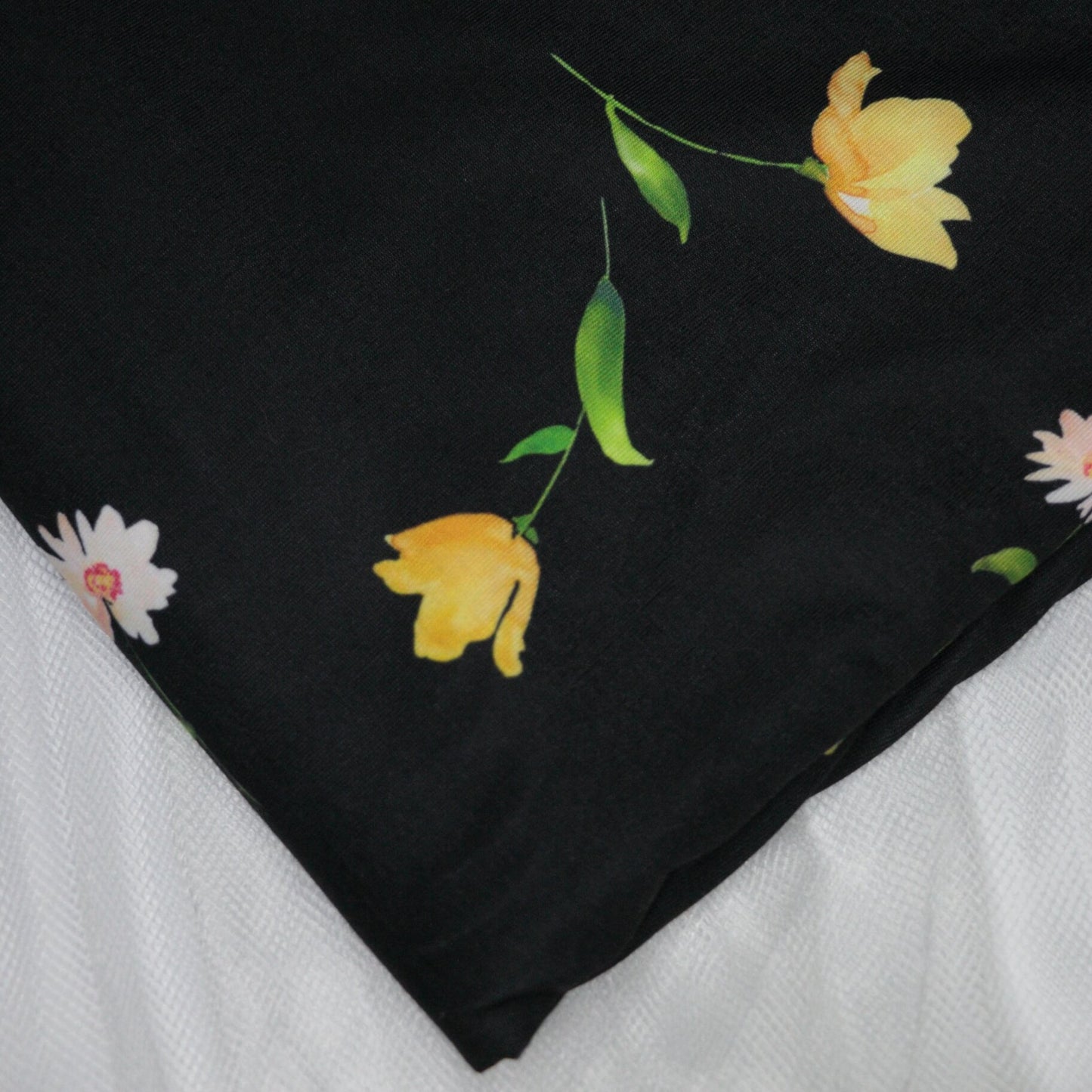 Black fabric with yellow floral patterns on a white background
