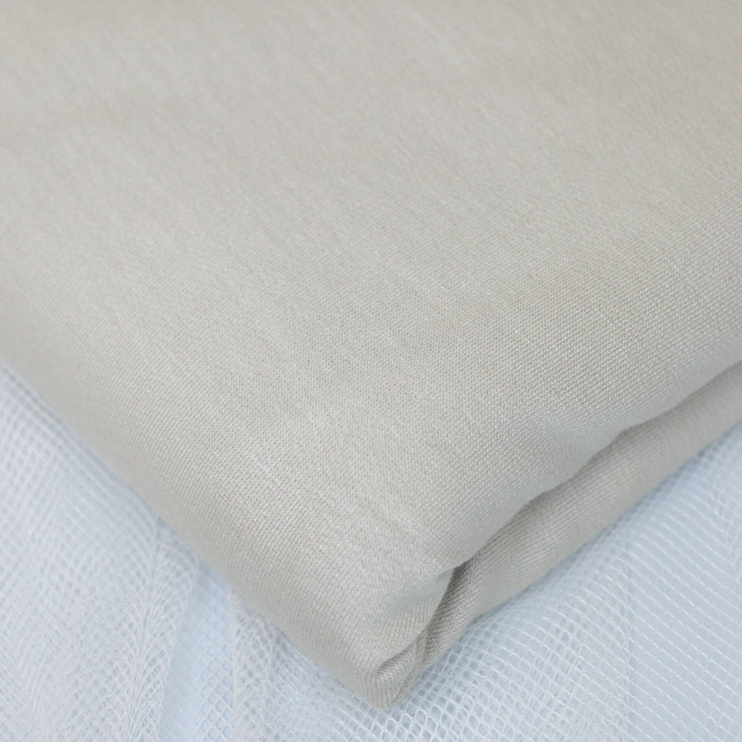 Close-up of beige fabric on a textured surface