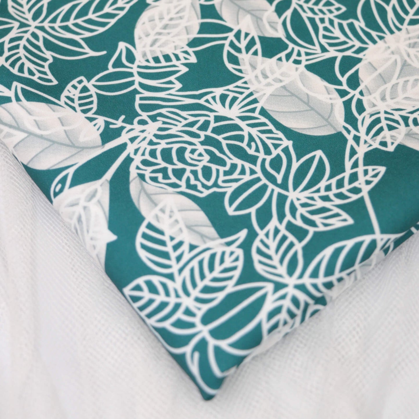 Teal fabric with white floral pattern on a white background