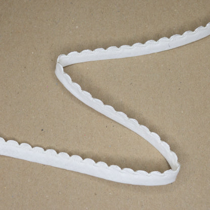 White scalloped ribbon on a brown cardboard background