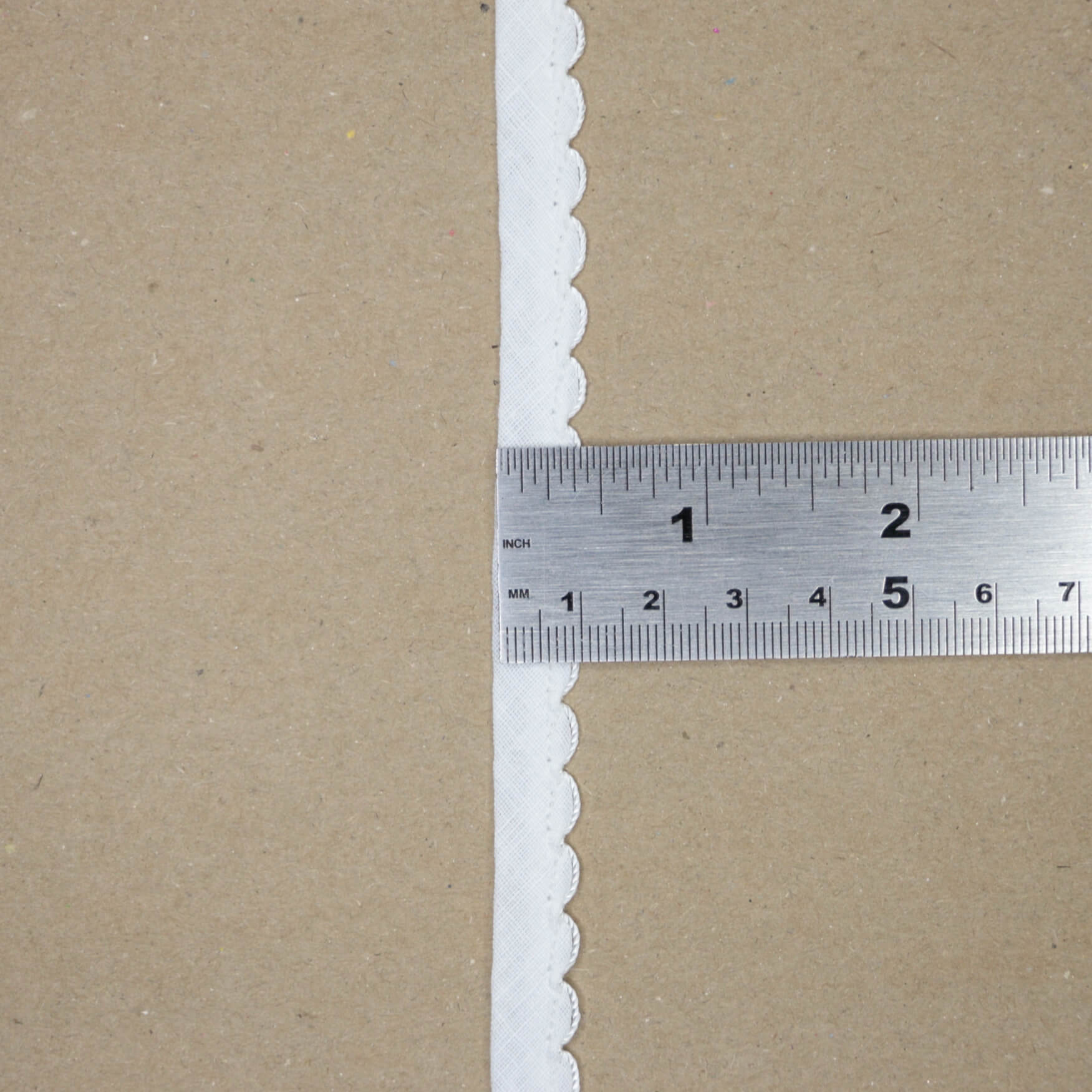 Brown paper with white scalloped edge and a ruler for scale.