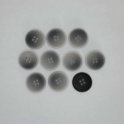 Ten round four-hole buttons arranged in a grid on a plain light background, with eight translucent gray buttons and one solid black button back.