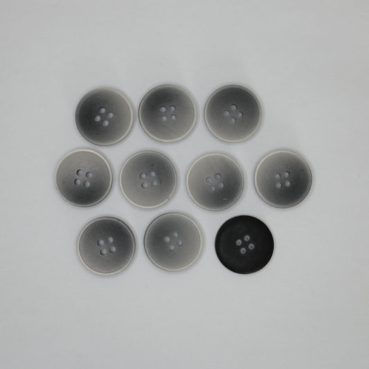 Ten round four-hole buttons arranged in a grid on a plain light background, with eight translucent gray buttons and one solid black button back.