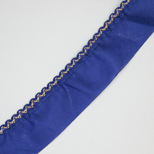 Close-up of a blue ribbon with decorative edge on a light gray background