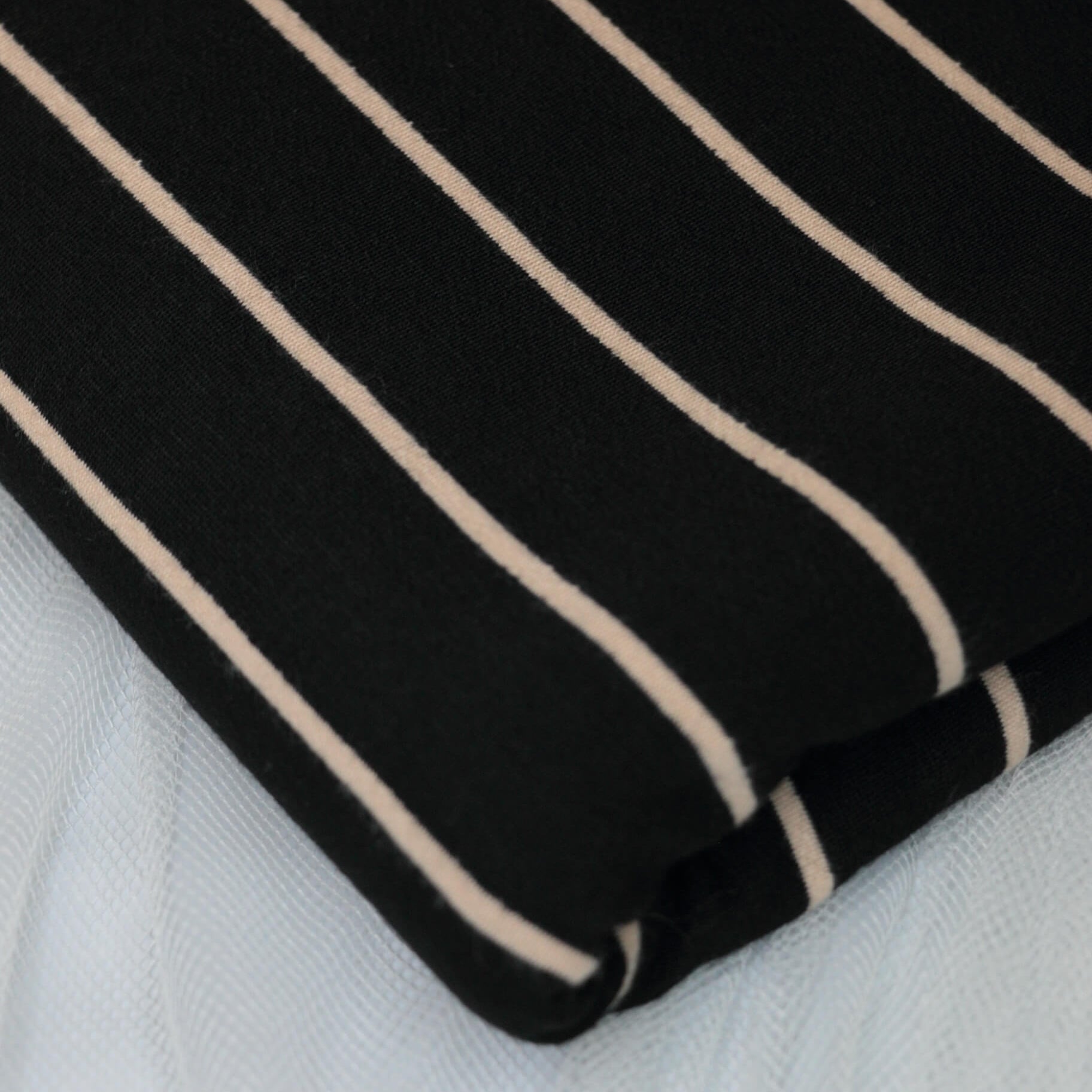 Black fabric with beige stripes on a white background