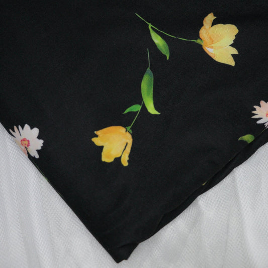 Black fabric with yellow floral patterns on a white background