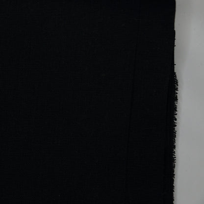 Black fabric with frayed edge on a white background