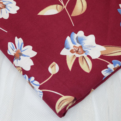 Floral fabric with blue and white flowers on a red background