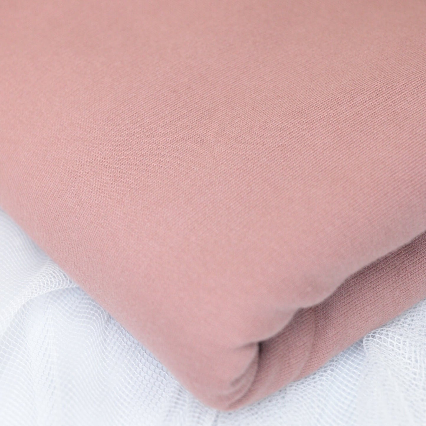Close-up of a pink fabric roll on a white background