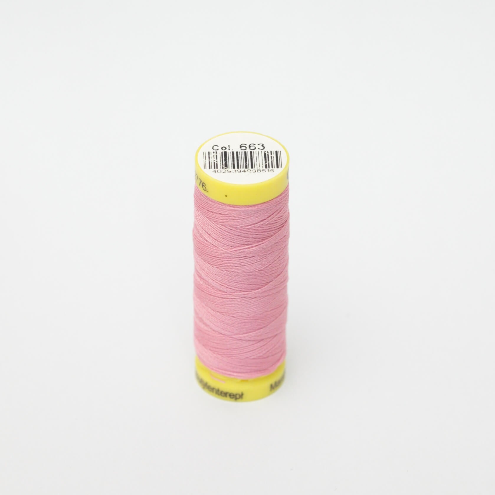 Spool of pink thread with a yellow label on a white background