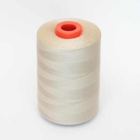 Spool of white thread with a red core on a light gray background