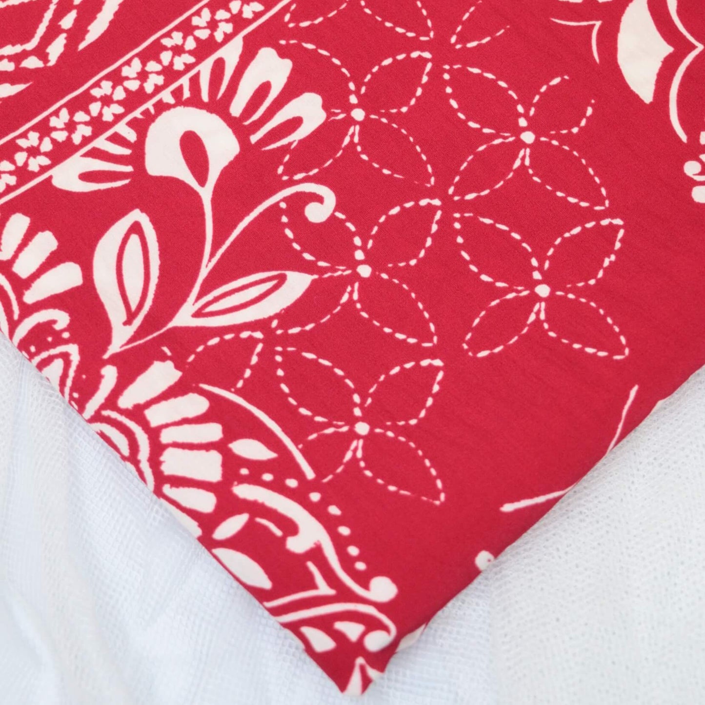 Red fabric with white floral and geometric patterns