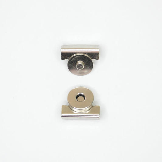 Two small metallic hardware components, magnetic clip parts, shown on a plain white background.