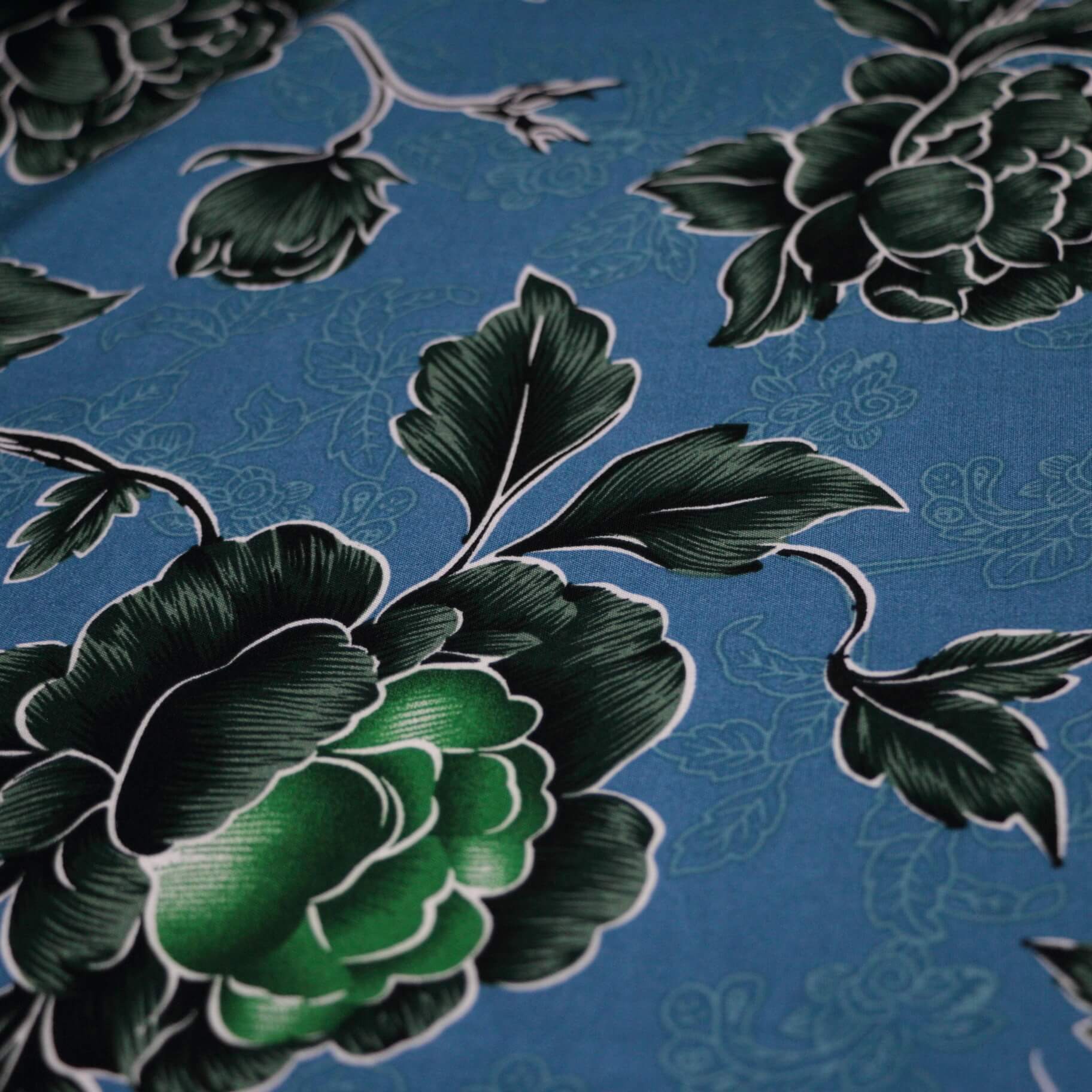 Close-up of green floral pattern on a blue background