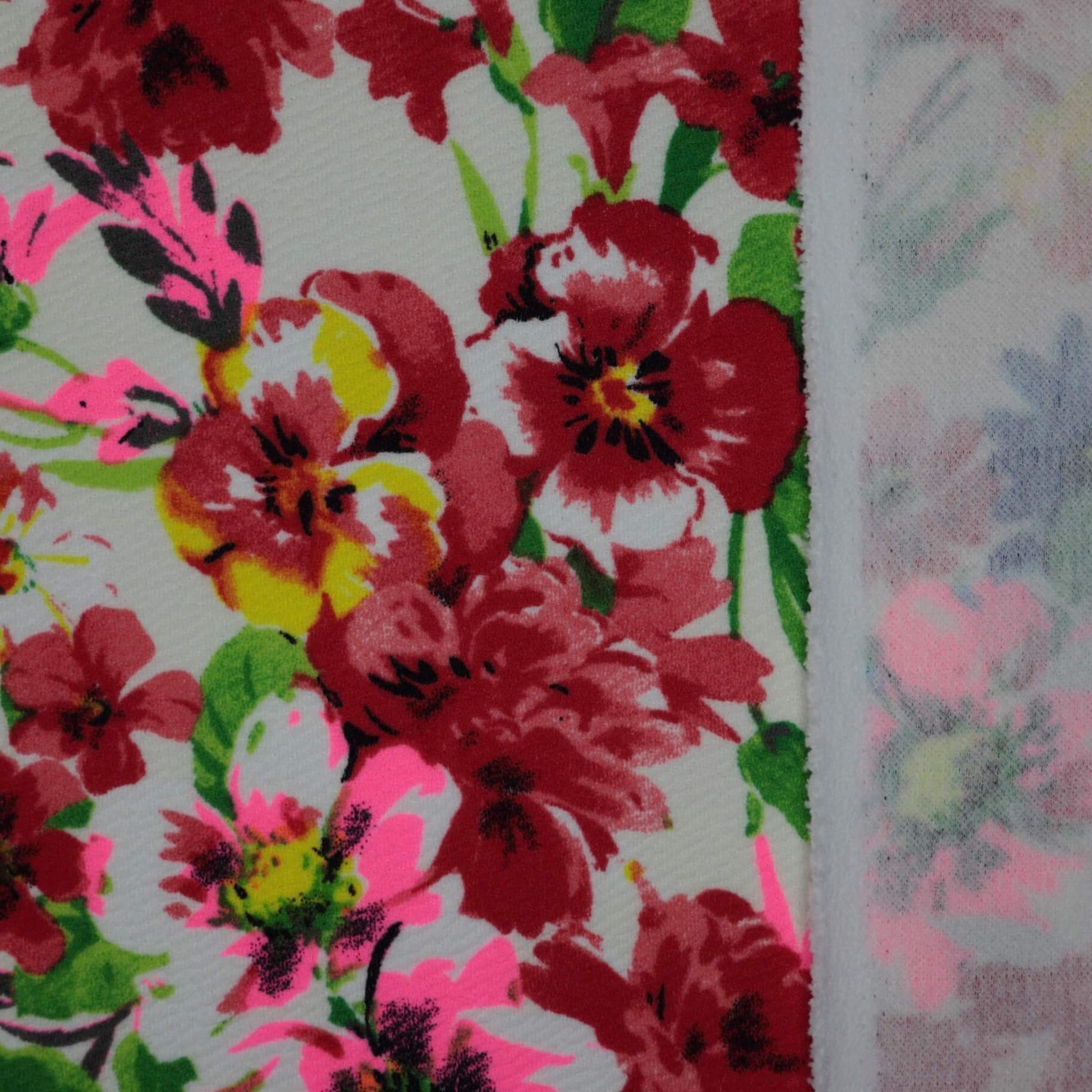 Close-up of a floral fabric pattern with red, pink, and green colors.