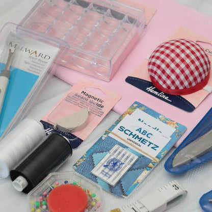 Collection of sewing tools and accessories on a white surface